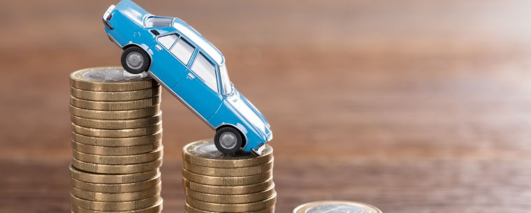 A toy car balancing on a stack of coins
