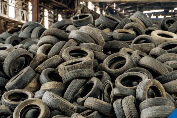 Large pile of wasted and used tyres at a garage.