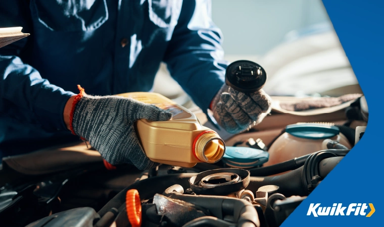 technician adding engine oil